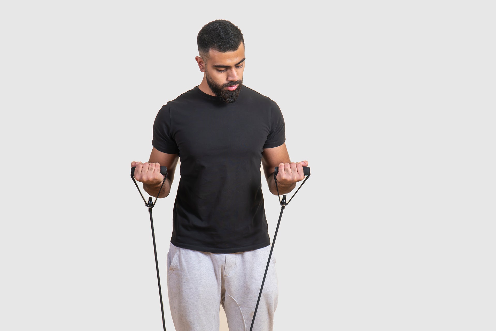 man exercising his biceps and arms with resistant tube and band.